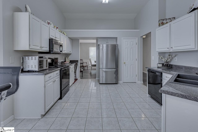 349 Hamilton Pkwy, Easley, SC 29642 - kitchen with black appliances, a sink, dark countertops, light tile patterned flooring, and white cabinets
