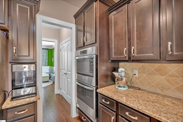 201 Wiscasset Way, Greenville, SC 29615 - kitchen with stainless steel double oven, dark brown cabinetry, tasteful backsplash, light stone countertops, and dark wood-type flooring