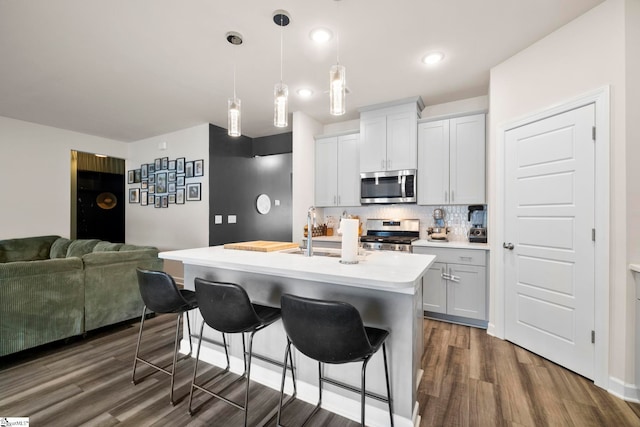 813 Elgon Walk Dr, Fountain Inn, SC 29644 - kitchen featuring stainless steel appliances, a sink, dark wood-type flooring, light countertops, and a breakfast bar