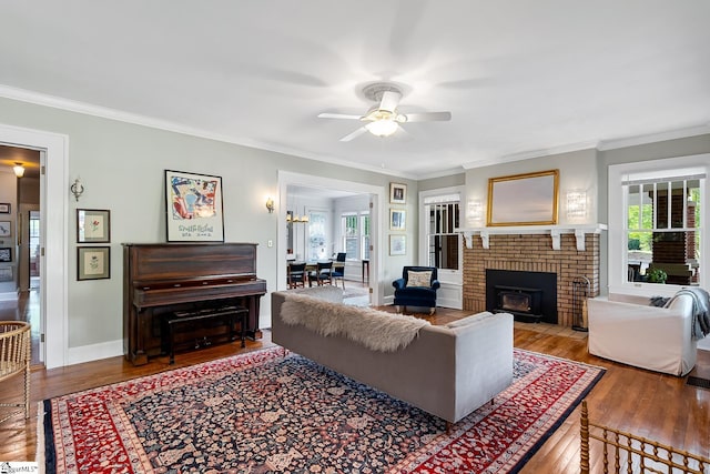227 S Main St, Anderson, SC 29654 - living room featuring a ceiling fan, hardwood / wood-style floors, ornamental molding, a brick fireplace, and baseboards