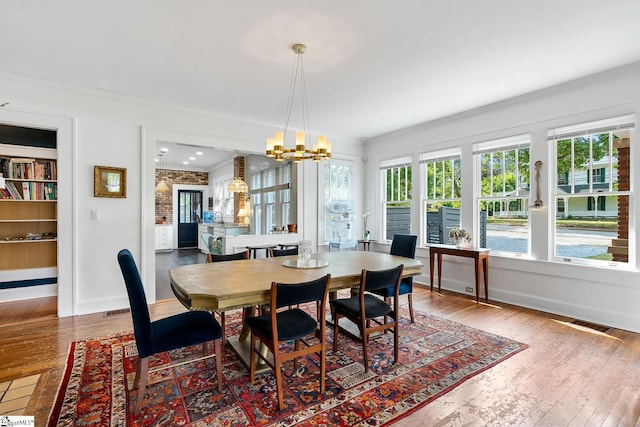 227 S Main St, Anderson, SC 29654 - dining space with crown molding, a chandelier, wood-type flooring, and baseboards