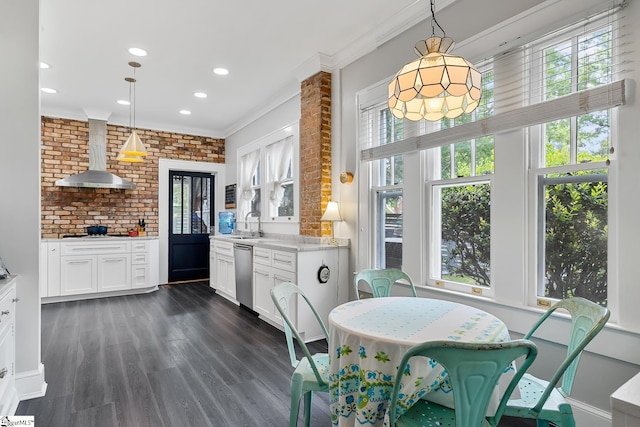227 S Main St, Anderson, SC 29654 - kitchen featuring wall chimney range hood, stainless steel dishwasher, ornamental molding, white cabinets, and dark wood-style floors