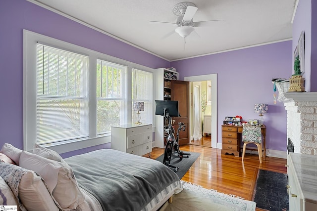 227 S Main St, Anderson, SC 29654 - bedroom featuring light wood-type flooring, crown molding, a brick fireplace, and ceiling fan