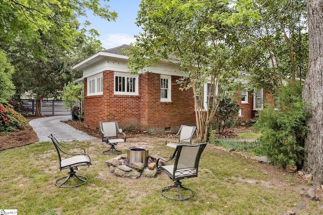 227 S Main St, Anderson, SC 29654 - view of side of property featuring crawl space, brick siding, and a fire pit