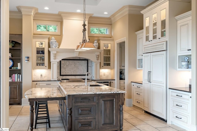 58 Wild Ginger Rd, Landrum, SC 29356 - kitchen with paneled built in fridge, decorative backsplash, a center island with sink, a sink, and a breakfast bar area