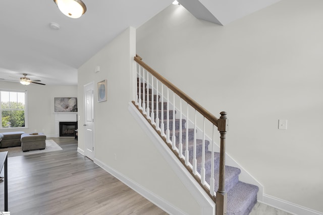 115 River Trace Loop, Simpsonville, SC 29680 - stairs featuring ceiling fan, wood finished floors, a glass covered fireplace, and baseboards
