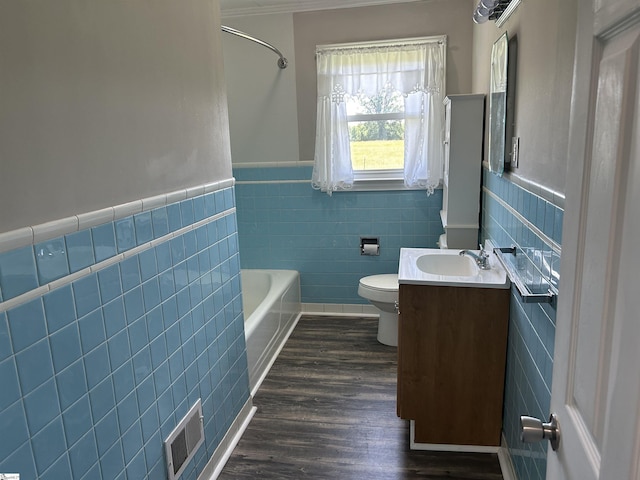 325 Byrnes St, Joanna, SC 29351 - full bath with tile walls, a tub to relax in, toilet, vanity, and wood finished floors