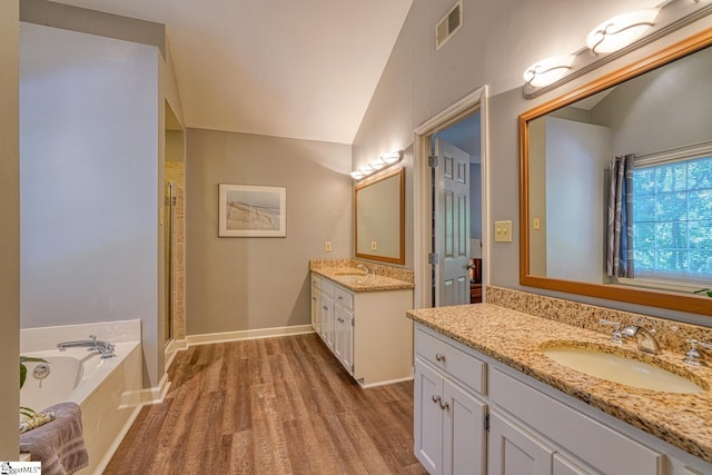 201 Woodridge Dr, Spartanburg, SC 29301 - bathroom featuring wood finished floors, two vanities, a shower stall, a bath, and lofted ceiling