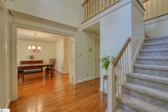201 Woodridge Dr, Spartanburg, SC 29301 - stairs featuring crown molding, wood finished floors, a chandelier, and baseboards