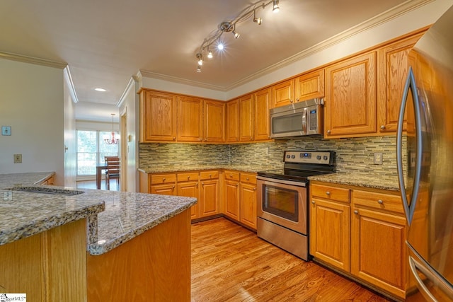 201 Woodridge Dr, Spartanburg, SC 29301 - kitchen featuring appliances with stainless steel finishes, light wood-style floors, crown molding, decorative backsplash, and light stone countertops