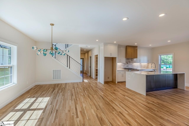 11 Stall St, Greenville, SC 29609 - kitchen featuring light wood-style floors, a sink, white cabinets, light countertops, and recessed lighting