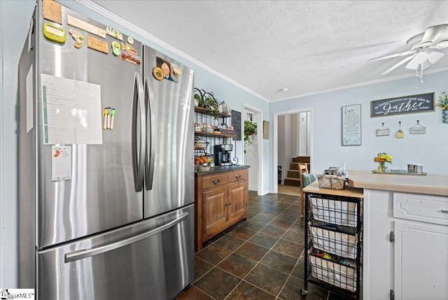 116 Kennedy St, Easley, SC 29642 - kitchen with freestanding refrigerator, ornamental molding, a ceiling fan, brown cabinets, and a textured ceiling
