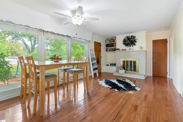 2807 Bellview Rd, Anderson, SC 29621 - dining space featuring ceiling fan, ornamental molding, wood-type flooring, and a fireplace