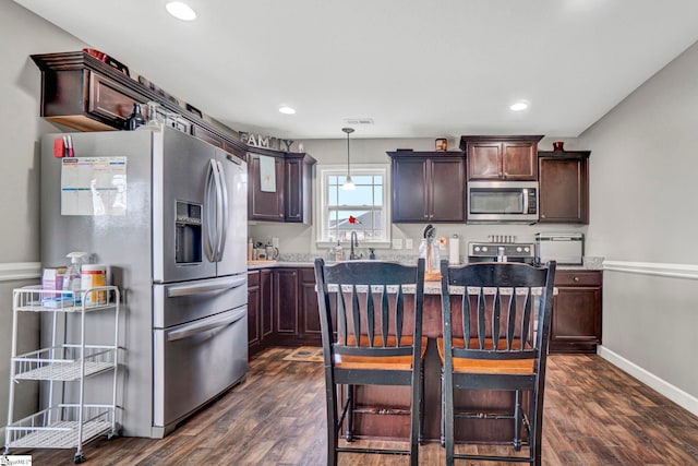105 Devonfield Dr, Greer, SC 29651 - kitchen featuring appliances with stainless steel finishes, dark brown cabinets, dark wood-style floors, recessed lighting, and pendant lighting