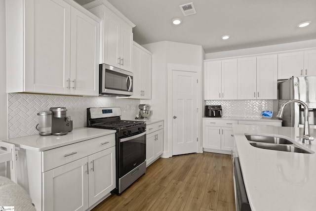 117 Hazelcroft Dr, Fountain Inn, SC 29644 - kitchen with stainless steel appliances, a sink, light countertops, white cabinets, and decorative backsplash