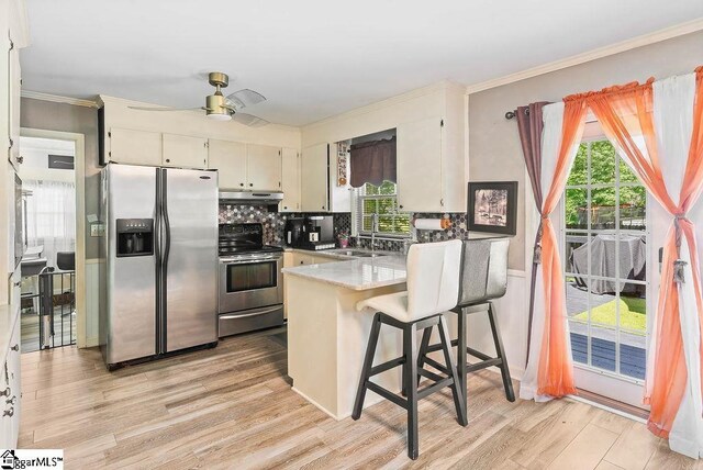 3 Creighton Ct, Taylors, SC 29687 - kitchen featuring stainless steel appliances, under cabinet range hood, a sink, a peninsula, and light wood-style floors