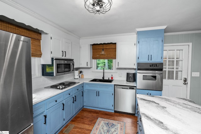 110 Sycamore Dr, Mauldin, SC 29662 - kitchen featuring stainless steel appliances, a sink, blue cabinetry, ornamental molding, and backsplash