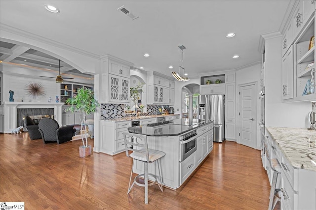 135 Neal Pointe Dr, Chesnee, SC 29323 - kitchen with stainless steel appliances, arched walkways, a ceiling fan, white cabinets, and a center island