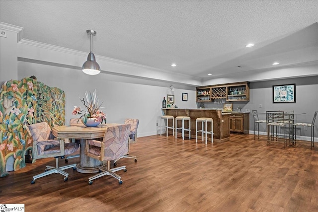 135 Neal Pointe Dr, Chesnee, SC 29323 - dining area featuring bar with sink, crown molding, wood finished floors, baseboards, and a textured ceiling