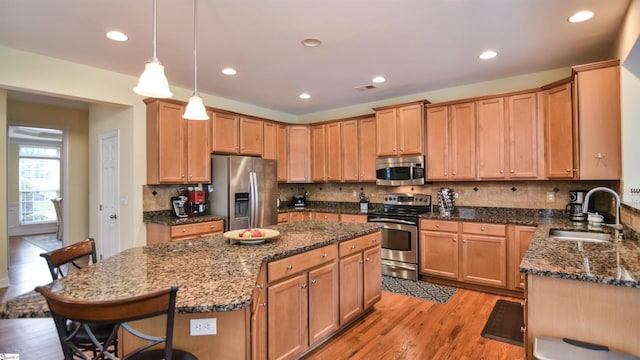 225 Highgrove Ct, Simpsonville, SC 29681 - kitchen with stainless steel appliances, a sink, a center island, a breakfast bar area, and dark stone counters
