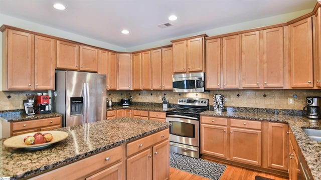 225 Highgrove Ct, Simpsonville, SC 29681 - kitchen featuring stainless steel appliances, dark stone counters, light wood finished floors, recessed lighting, and tasteful backsplash