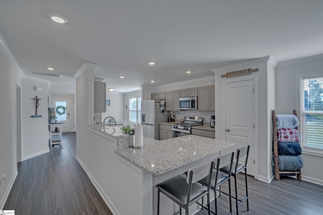 105 Ella B Ln, Easley, SC 29640 - kitchen featuring appliances with stainless steel finishes, baseboards, dark wood finished floors, a breakfast bar, and crown molding