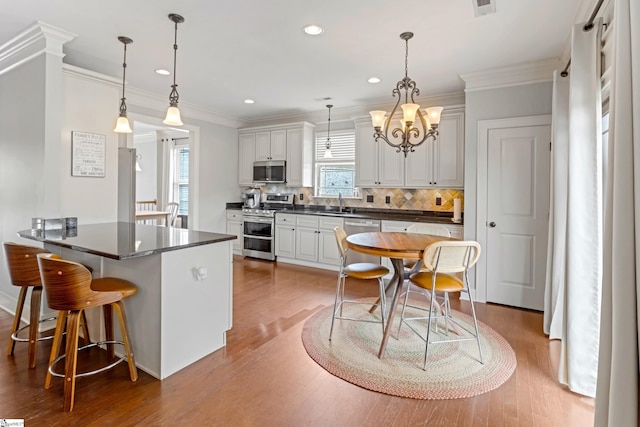 10 Croydon Way, Greenville, SC 29609 - kitchen with appliances with stainless steel finishes, dark countertops, a peninsula, decorative backsplash, and crown molding