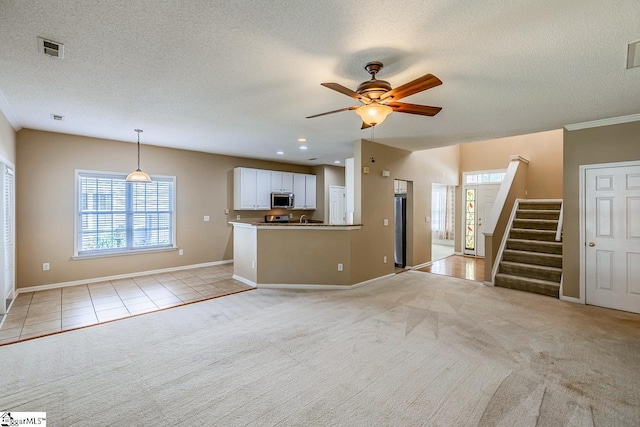 122 N Orchard Farms Ave, Simpsonville, SC 29681 - unfurnished living room with healthy amount of natural light, light colored carpet, ceiling fan, and a textured ceiling