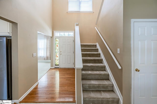 122 N Orchard Farms Ave, Simpsonville, SC 29681 - entrance foyer with healthy amount of natural light, stairs, light wood-style floors, a high ceiling, and baseboards