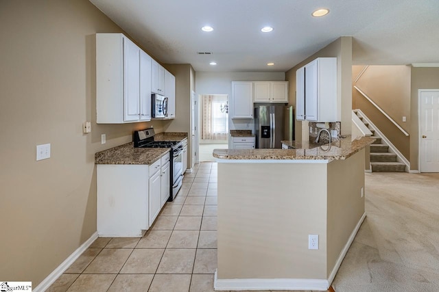 122 N Orchard Farms Ave, Simpsonville, SC 29681 - kitchen with appliances with stainless steel finishes, white cabinets, baseboards, a peninsula, and dark stone countertops