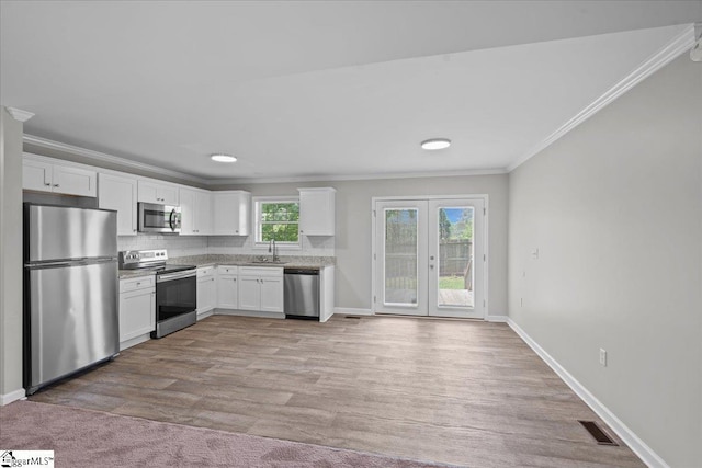 514 Habersham Ln, Easley, SC 29642 - kitchen featuring stainless steel appliances, a sink, crown molding, white cabinetry, and baseboards