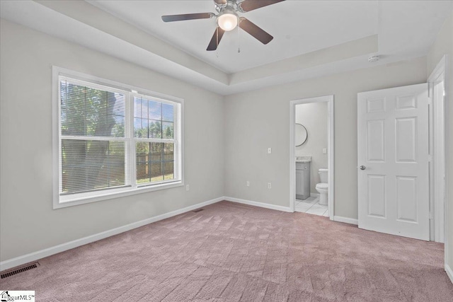 514 Habersham Ln, Easley, SC 29642 - unfurnished bedroom with light colored carpet, baseboards, a tray ceiling, ensuite bathroom, and a ceiling fan