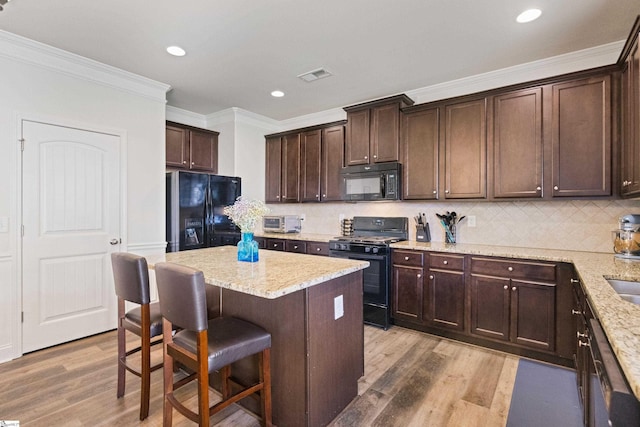 412 Kindletree Way, Simpsonville, SC 29680 - kitchen with black appliances, ornamental molding, light wood finished floors, dark brown cabinetry, and a breakfast bar area
