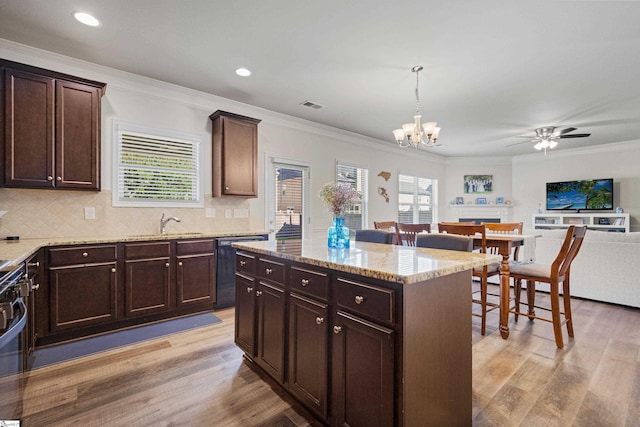 412 Kindletree Way, Simpsonville, SC 29680 - kitchen with light wood finished floors, open floor plan, dark brown cabinetry, ornamental molding, and recessed lighting
