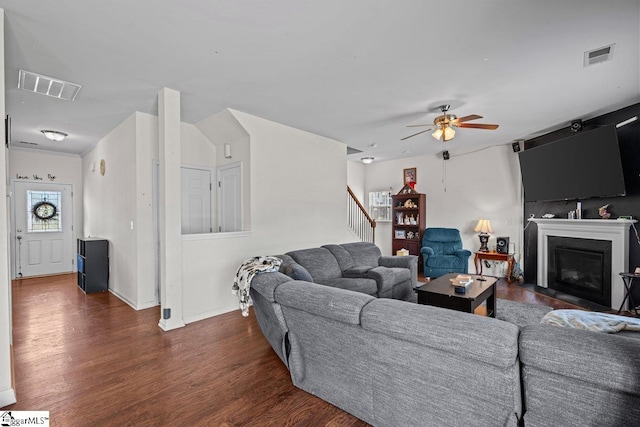 559 Falls Cottage Run, Boiling Springs, SC 29316 - living room featuring dark wood-style floors, a ceiling fan, a glass covered fireplace, baseboards, and stairs