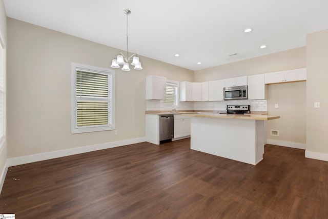 184 Sandifer Rd, Spartanburg, SC 29303 - kitchen featuring stainless steel appliances, white cabinetry, a chandelier, baseboards, and dark wood-style floors