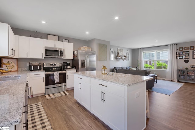 212 Ralston Dr, Greer, SC 29651 - kitchen with appliances with stainless steel finishes, a sink, open floor plan, wood finished floors, and a kitchen island