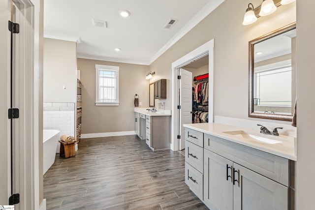 222 Blease Horton Rd, Boiling Springs, SC 29316 - full bathroom with ornamental molding, two vanities, a soaking tub, wood finished floors, and baseboards