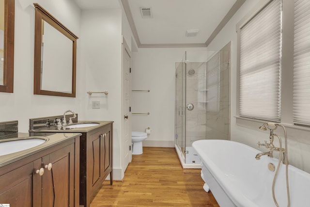 509B Townes St, Greenville, SC 29601 - bathroom featuring two vanities, a shower stall, toilet, a freestanding tub, and wood finished floors