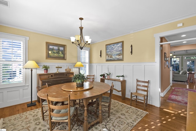 509B Townes St, Greenville, SC 29601 - dining room with a decorative wall, a chandelier, a wainscoted wall, wood finished floors, and crown molding