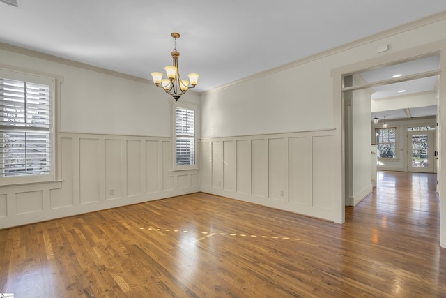 509B Townes St, Greenville, SC 29601 - spare room with a chandelier, a decorative wall, wood finished floors, a wainscoted wall, and crown molding