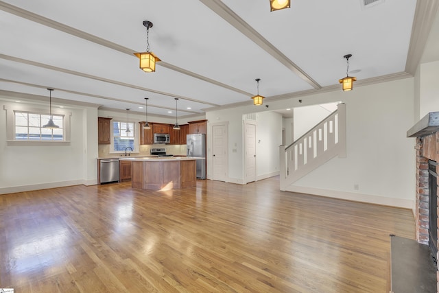 509B Townes St, Greenville, SC 29601 - unfurnished living room with baseboards, light wood-type flooring, a brick fireplace, ornamental molding, and beamed ceiling