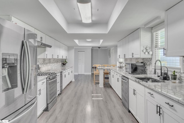 203 Rock Springs Rd, Belton, SC 29627 - kitchen with appliances with stainless steel finishes, under cabinet range hood, a sink, light wood-type flooring, and white cabinets