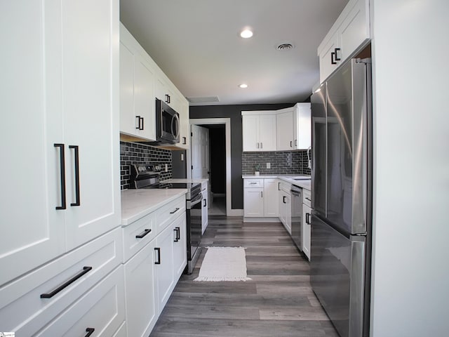 310 Sloping Meadow Dr, Inman, SC 29349 - kitchen with appliances with stainless steel finishes, backsplash, recessed lighting, white cabinets, and wood finished floors