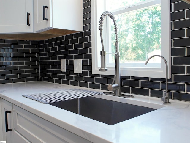 310 Sloping Meadow Dr, Inman, SC 29349 - kitchen view of white cabinets, tasteful backsplash, a sink, and light stone countertops
