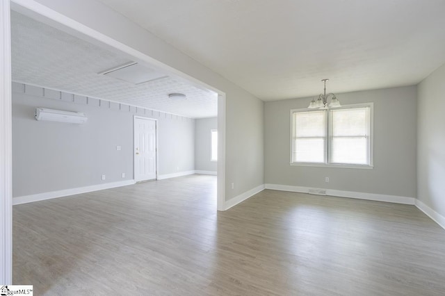 112 Summer Dr, Easley, SC 29642 - unfurnished room with a chandelier, a wall mounted AC, healthy amount of natural light, and wood finished floors