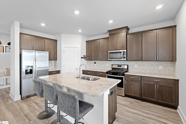 101 Hazelcroft Dr, Fountain Inn, SC 29644 - kitchen featuring appliances with stainless steel finishes, a sink, light wood-style flooring, tasteful backsplash, and recessed lighting
