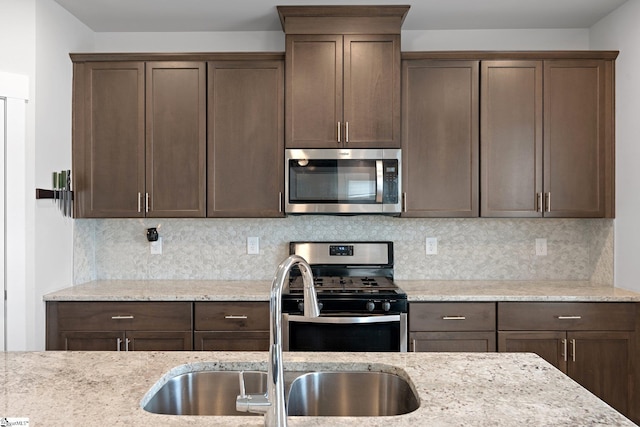 101 Hazelcroft Dr, Fountain Inn, SC 29644 - kitchen with appliances with stainless steel finishes, a sink, dark brown cabinets, backsplash, and light stone counters
