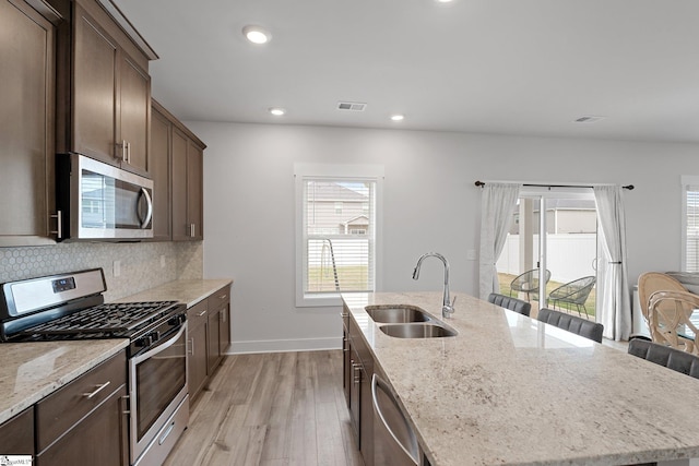 101 Hazelcroft Dr, Fountain Inn, SC 29644 - kitchen with appliances with stainless steel finishes, a sink, light wood-type flooring, a kitchen island with sink, and healthy amount of natural light