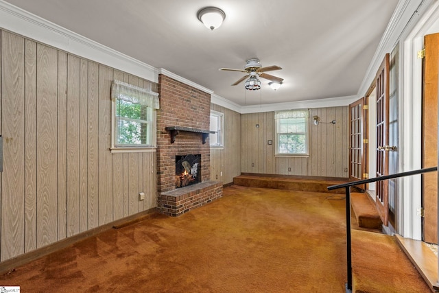 303 Suber Rd, Greer, SC 29651 - unfurnished living room with ornamental molding, ceiling fan, a brick fireplace, carpet, and wood walls